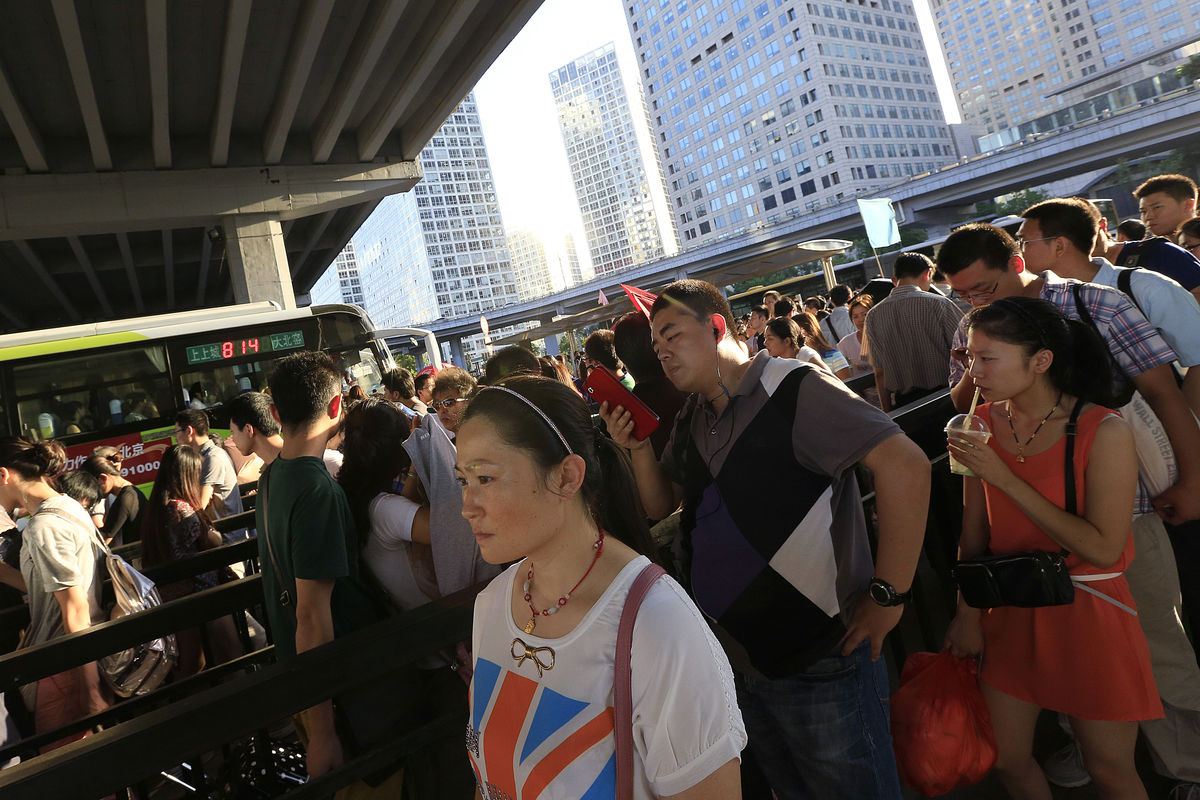 Commuters wait for buses in the central business district of Beijing, China.